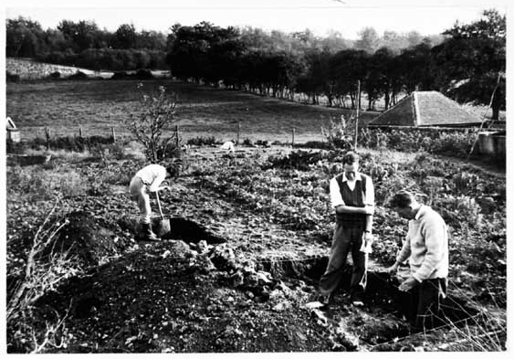 Three people working in a trench on an archaeological dig in Pitlands Farm in Up Marden 