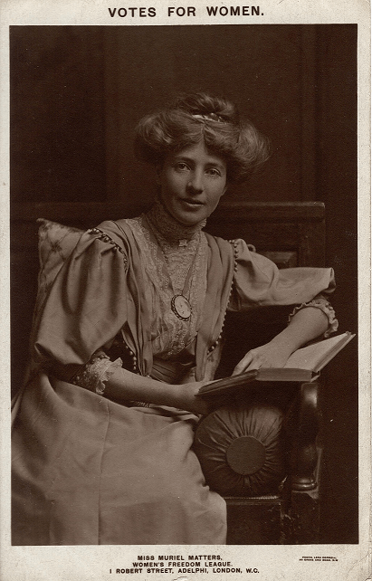 Sepia portrait of Muriel Matters, seated with a book, looking directly at the camera