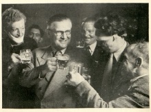 Five men with raised beer glasses standing around Doctor McIndoe, who also had a full glass of beer