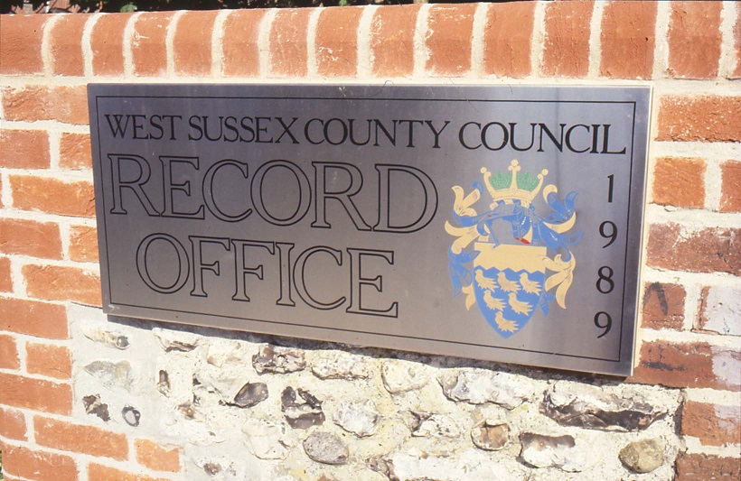 Mounted to brink and flint wall, reads West Sussex County Council, Record Office, 1989, with council crest (colour)
