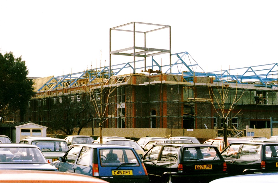 Colour photograph showing the brickwork to the ground and first floor complete, with some roof timbers in place