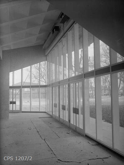 A black and white photograph of the newly completed Theatre auditorium with its large windows overlooking Oaklands Park.