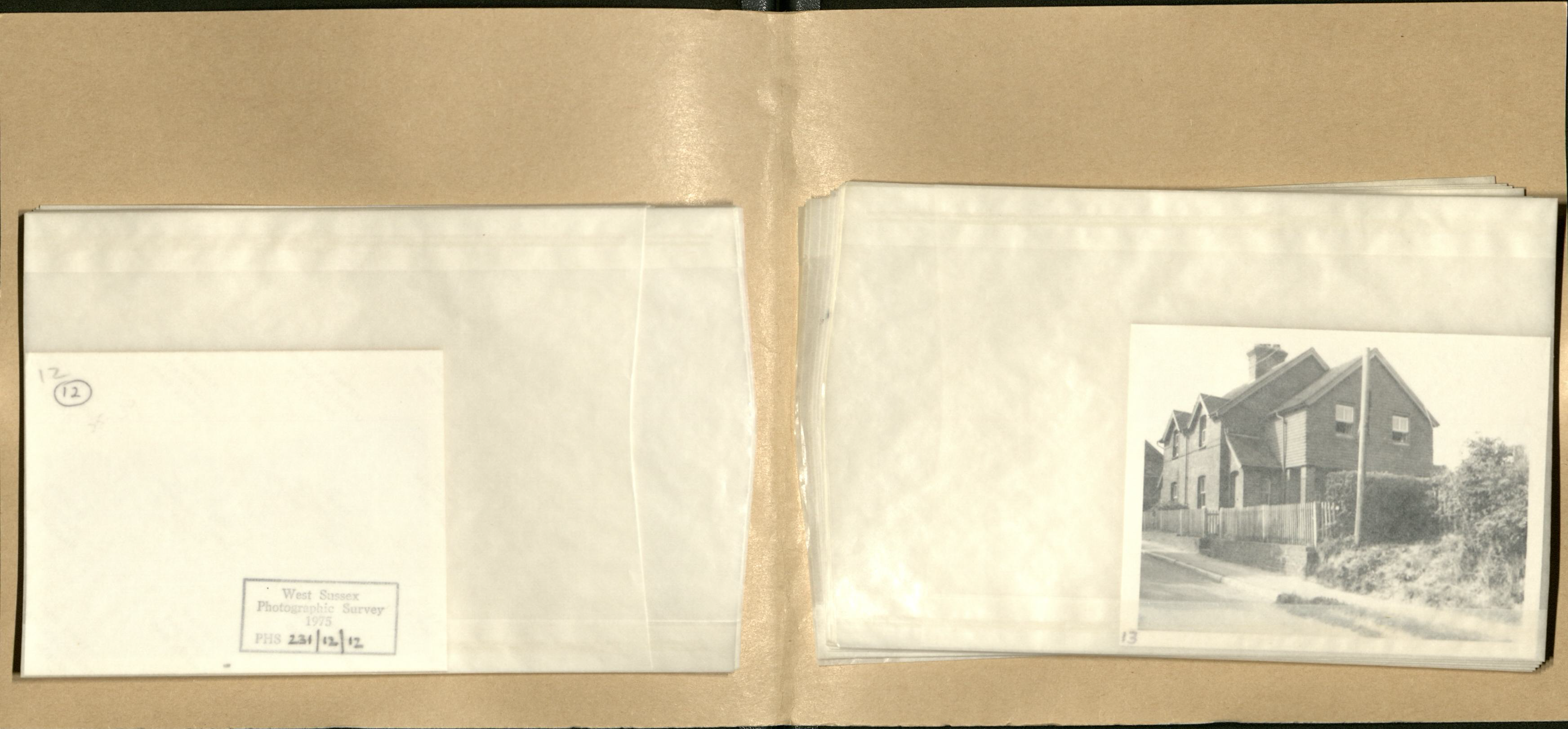 The square brown folder is opened, and within are dozens of individually enveloped photographs of properties in Ardingley.