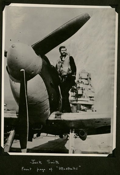 In uniform and standing on the wing of his plane, Jack looks off to the middle distance. The caption reads: Caption: 'Front page of "Illustrated" [Illustrated London News].'