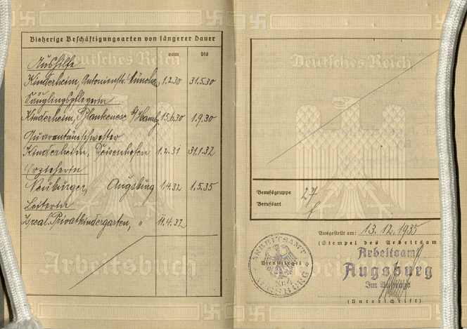 Open two page spread of a workbook. Embossed on the pages are a Nazi eagle and several swastikas.