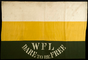 Banner made up of three horizontal stripes with white at the top, yellow in the middle and dark green at the bottom. WFL DARE TO BE FREE is stencilled at the bottom, along the green stripe.